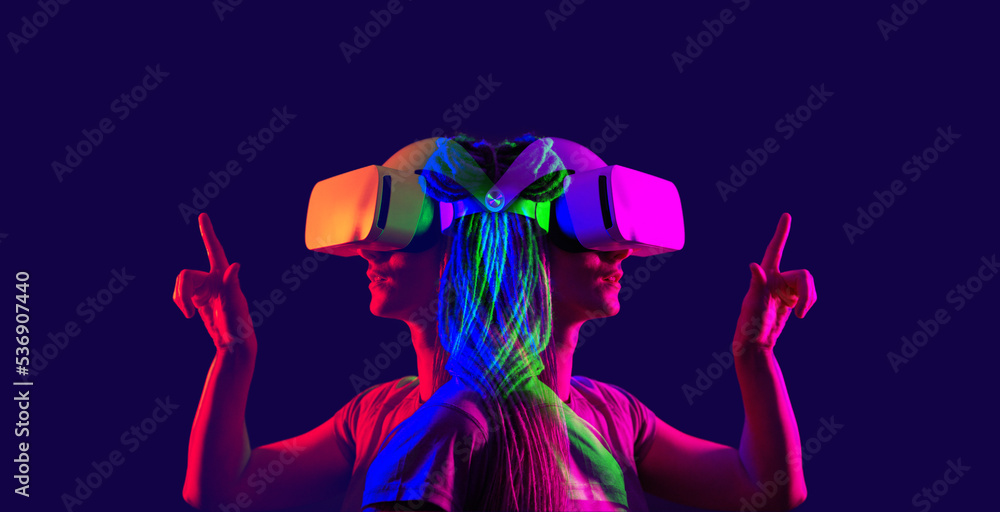Woman is using virtual reality headset. Image with double color exposure effect.
