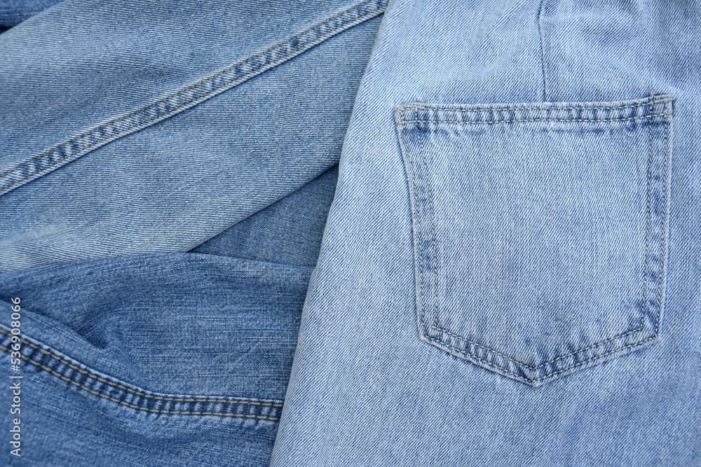 Lots of jeans pants in a stack. Denim background. Lots of jeans pants in a stack. Denim background.