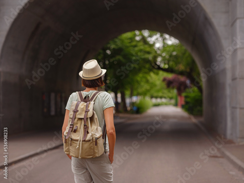 travel to summer Europe young asian woman. Woman having a great vacation in Switzerland, Basel. Lady walks along embankment of Rhine river