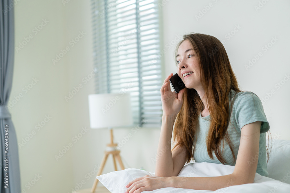 Young Caucasian woman use mobile phone call on bed at home in morning. Young Caucasian woman use mobile phone call on bed at home in morning.