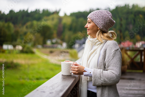Φωτογραφία Beautiful woman standing on terrace drinking tea contemplating nature