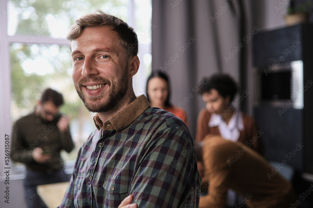 portrait smiling confident businessman standing in modern office room with arms crossed, diverse colleagues on background portrait smiling confident businessman standing in modern office room with arms crossed, diverse colleagues on background