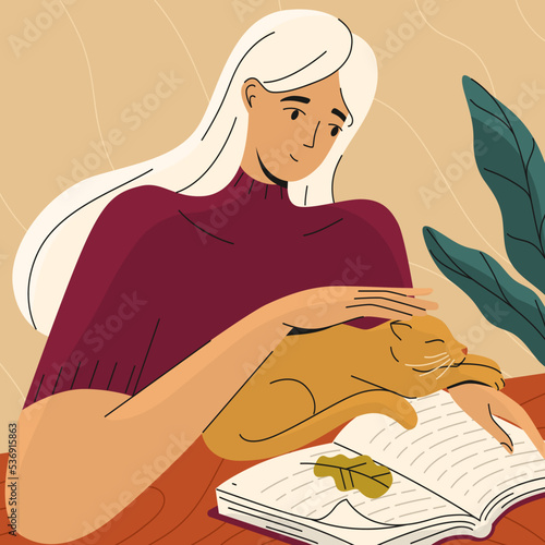 Young woman reading a book with a cat by table.