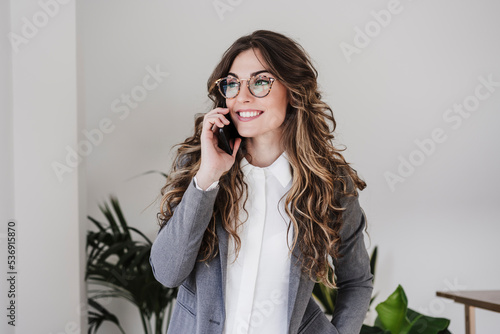 Smiling businesswoman using mobile phone in the office