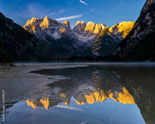 Italy, Trentino-Alto Adige/Sudtirol, Mountains reflecting in Lago di Landro at dusk photo