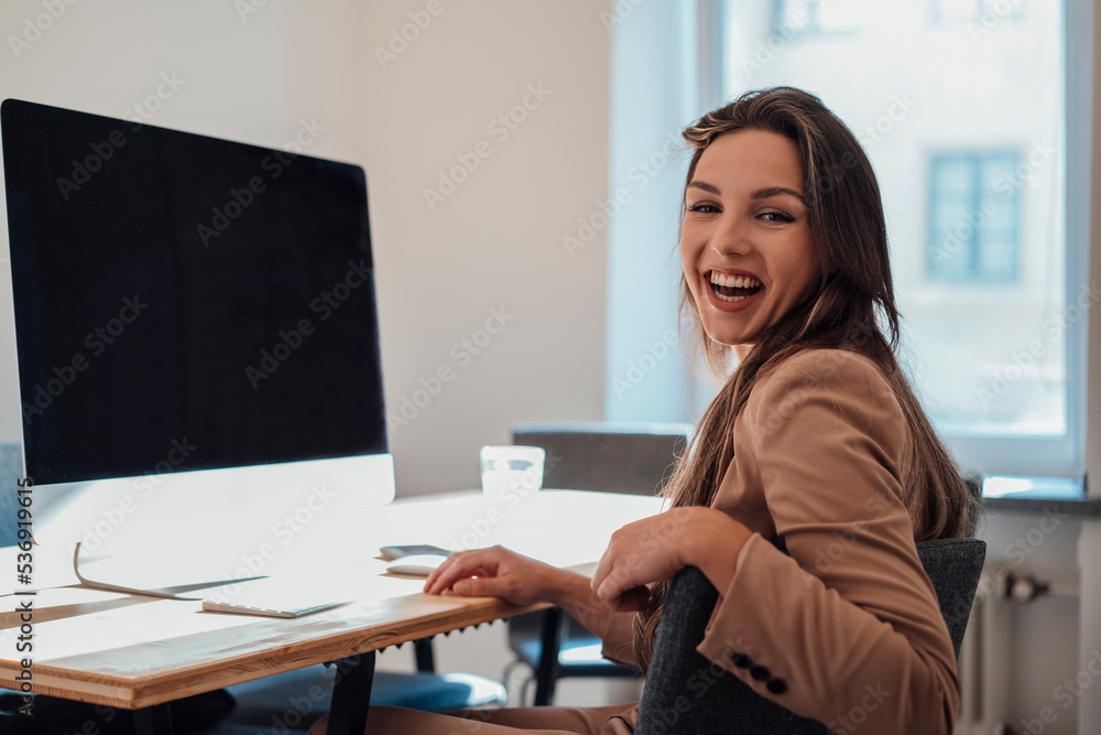 Cheerful young freelancer sitting in front of desktop PC at home office Cheerful young freelancer sitting in front of desktop PC at home office