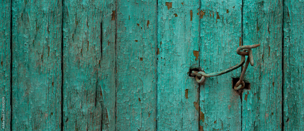 Banner with wooden green old fence with peeling paint. Hook for closing the door. Place for text. The concept of devastation, old age and destruction of the old world. Closing borders. Copyspace Banner with wooden green old fence with peeling paint. Hook for closing the door. Place for text. The concept of devastation, old age and destruction of the old world. Closing borders. Copyspace