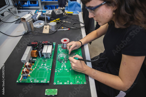 Technician soldering mother board in electronics industry photo