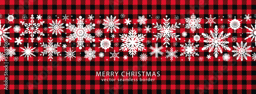 Snowflakes on a Buffalo plaid background..Vector border seamless pattern. Festive winter texture..
