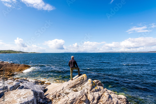 Man standing on rock at Loch Ailort lake photo