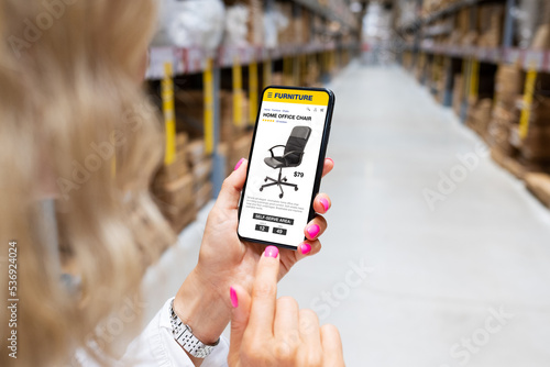 Woman picking up furniture in store's warehouse photo