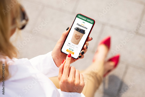 Foto Woman ordering coffee online for takeaway on mobile phone