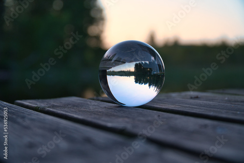 Glass ball on a wooden pier at a Swedish lake at evening hour. Nature Scandinavia