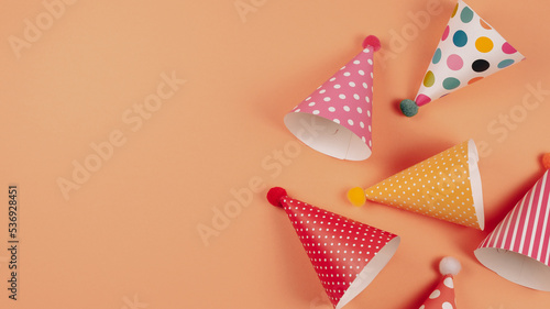 Colorful birthday caps on orange background.