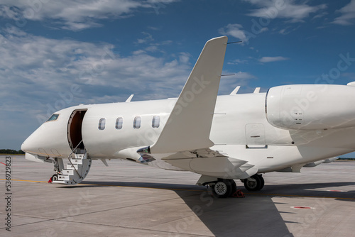 Quadro su tela Close-up modern white private jet with an opened gangway door at the airport apr