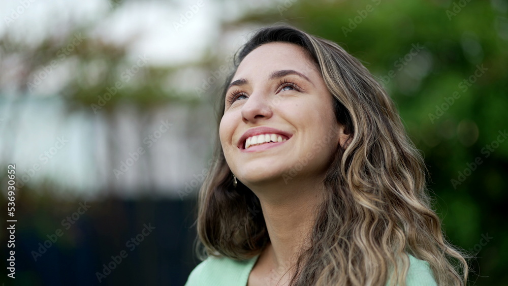 Portrait of a grateful contemplative young woman closeup face. Meditative 20s girl opening eyes to sky with gratitude