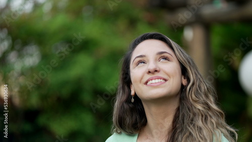 Portrait of a grateful contemplative young woman closeup face. Meditative 20s girl opening eyes to sky with gratitude