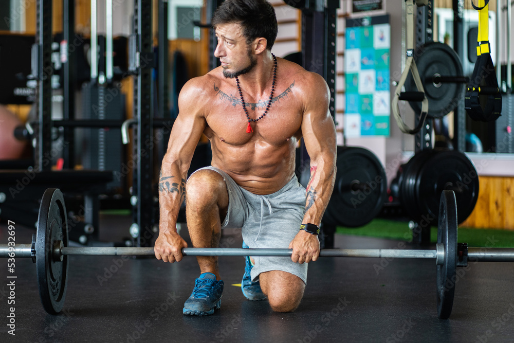 Man resting in a gym while exercising with weights Man resting in a gym while exercising with weights