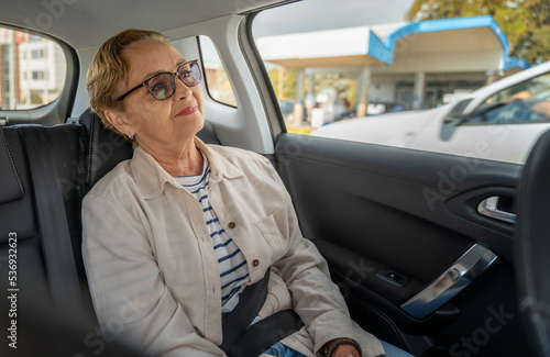 Obraz na płótnie Beautiful happy senior woman sitting in the passenger seat in the car enjoying the ride w salonie