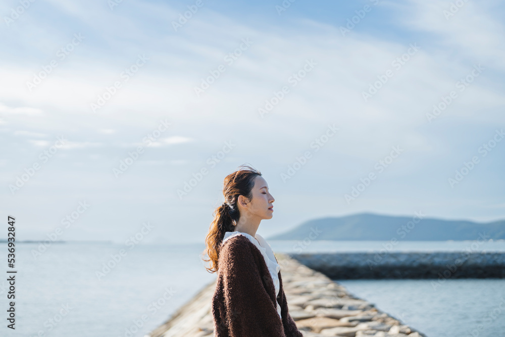 夕暮れの海にいる女性