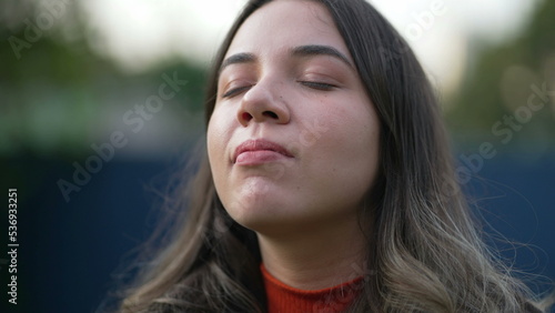 Serene peaceful young woman closing eyes in contemplation. Spiritual meditative millennial girl opening eye