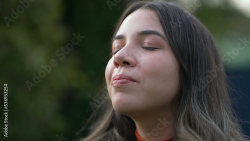 Serene peaceful young woman closing eyes in contemplation. Spiritual meditative millennial girl opening eye