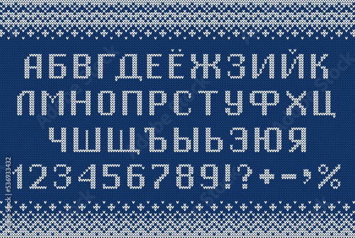 Cyrillic font in sweater style. Knitted russian letters, numbers and symbols for New Year holidays and winter season. Alphabet and scandinavian patterns on blue knit background. Typeface vector design