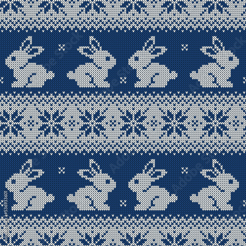 Knitted seamless pattern for 2023 new year of the rabbit. Vector background with cute bunnies and scandinavian ornaments. Dark blue and white sweater print.