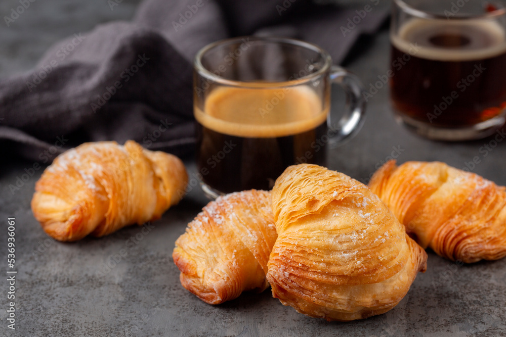Italian breakfast with coffee. Caffè Espresso and neapolitan shell-shaped pastry sfogliatelle riccia stuffed with ricotta, almond paste and candied peel of citron. Or lobster tail. Grey background.