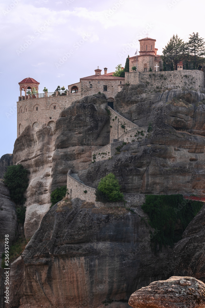 This curly stairway cut into imposing Meteora solid rock leads t o the entrance of the second largest historical complex of Holy Varlaam Monastery, Trikala, Thessaly, Greece, vertical photo