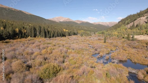 Flying low over beaver ponds up a valley towards Mount Silverheels in the distance.  Rocky Mountains in the fall filmed along Boreas Pass Road near the town of Como, Colorado. photo