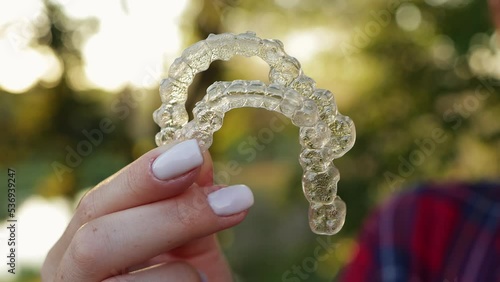 Close-up of hand holding Invisible aligners for straightening teeth. Dental care.