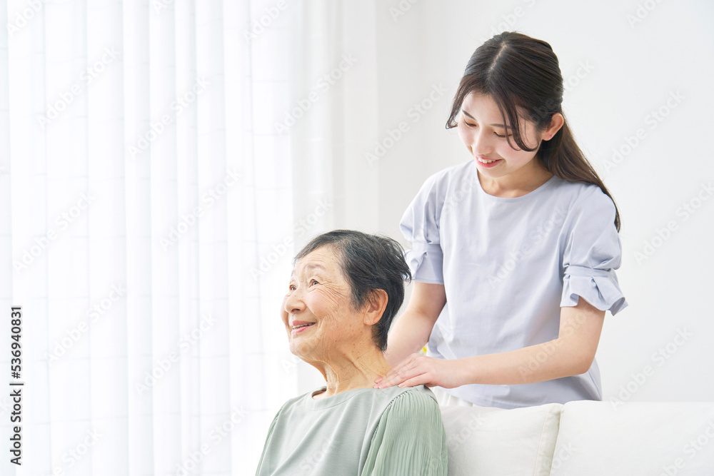祖母の肩揉みをする孫 祖母の肩揉みをする孫