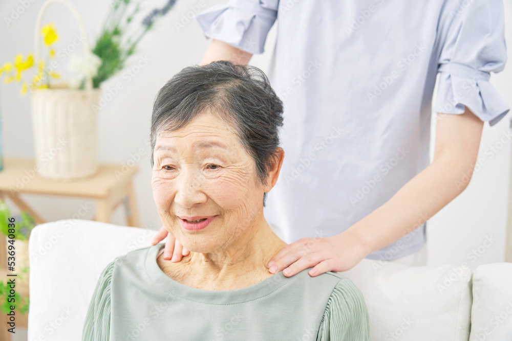 Fototapeta premium 肩揉みをされる高齢者女性