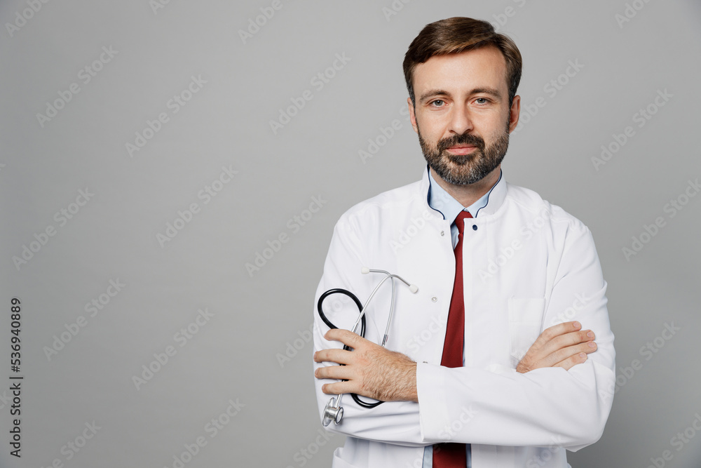 Male doctor confident man wears white medical gown suit stethoscope work in hospital hold hands crossed look camera isolated on plain grey color background studio portrait Healthcare medicine concept Male doctor confident man wears white medical gown suit stethoscope work in hospital hold hands crossed look camera isolated on plain grey color background studio portrait Healthcare medicine concept