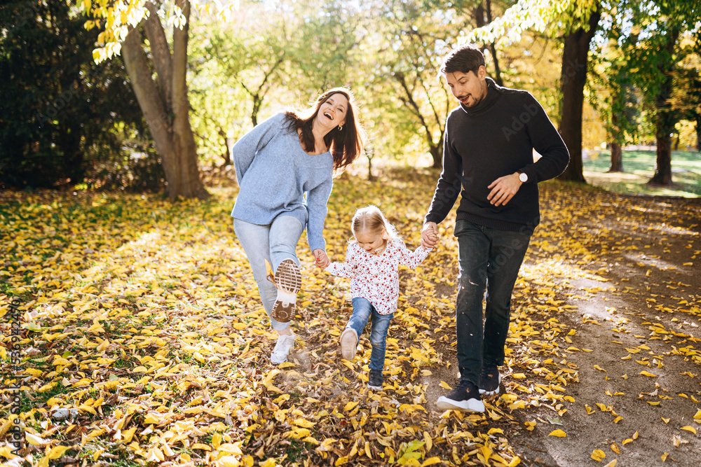 happy family with little daughter in autumn park outdoor recreation.