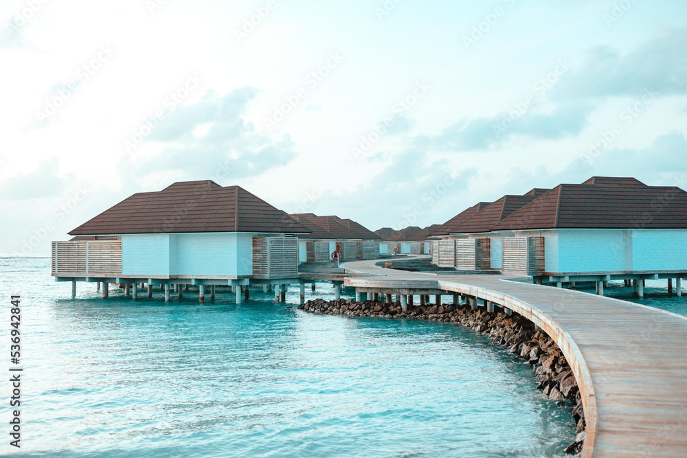 picturesque sunrise in the Maldive island, view on water villas at sunrise in Maldives, concept of luxury travel and vacation