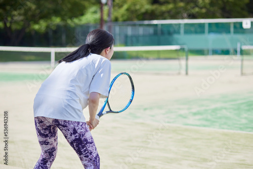 テニスコートでテニスをする若い日本人女性 © west_photo
