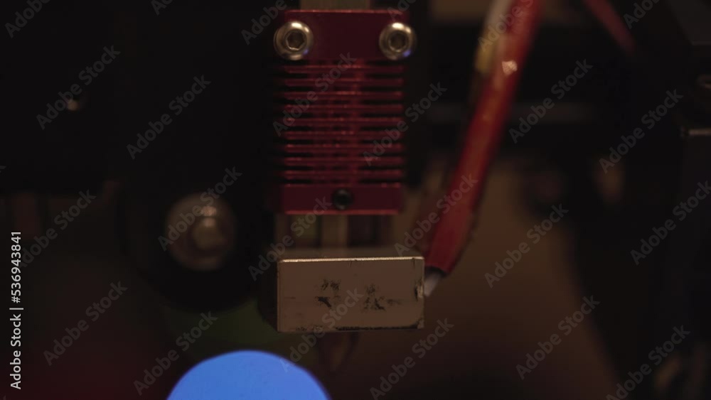 3D printer nozzle extruder hotend with lights of technology flashing in the background 3D printer nozzle extruder hotend with lights of technology flashing in the background