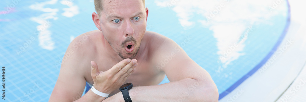 Obraz premium Shocked young man in the pool looks into a laptop