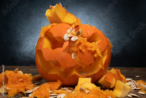 Crushed Halloween carved pumpkin lantern. Seeds and pieces scattered around. Creative pumpkin decorating ideas, scary spooky smashed Jack-o'-lantern carving cut out.