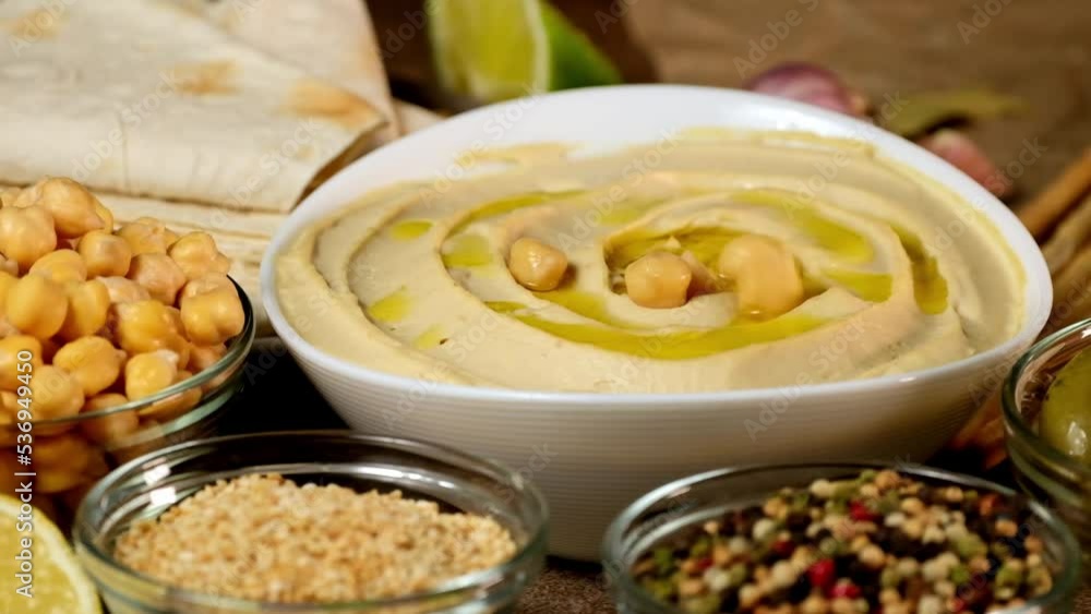 Chickpea hummus made from mashed chickpeas dip with tahini lemon garlic paprika and olive oil close-up. Enjoying yummy hummus with pita, lavash, bread sticks grissini. Kosher healthy vegan food rotate Chickpea hummus made from mashed chickpeas dip with tahini lemon garlic paprika and olive oil close-up. Enjoying yummy hummus with pita, lavash, bread sticks grissini. Kosher healthy vegan food rotate