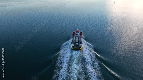 Casco Bay lines Cruise and travel taxi ferry vessel crosses water at sunrise. Aerial reveal of sunshine reflection on ocean. photo