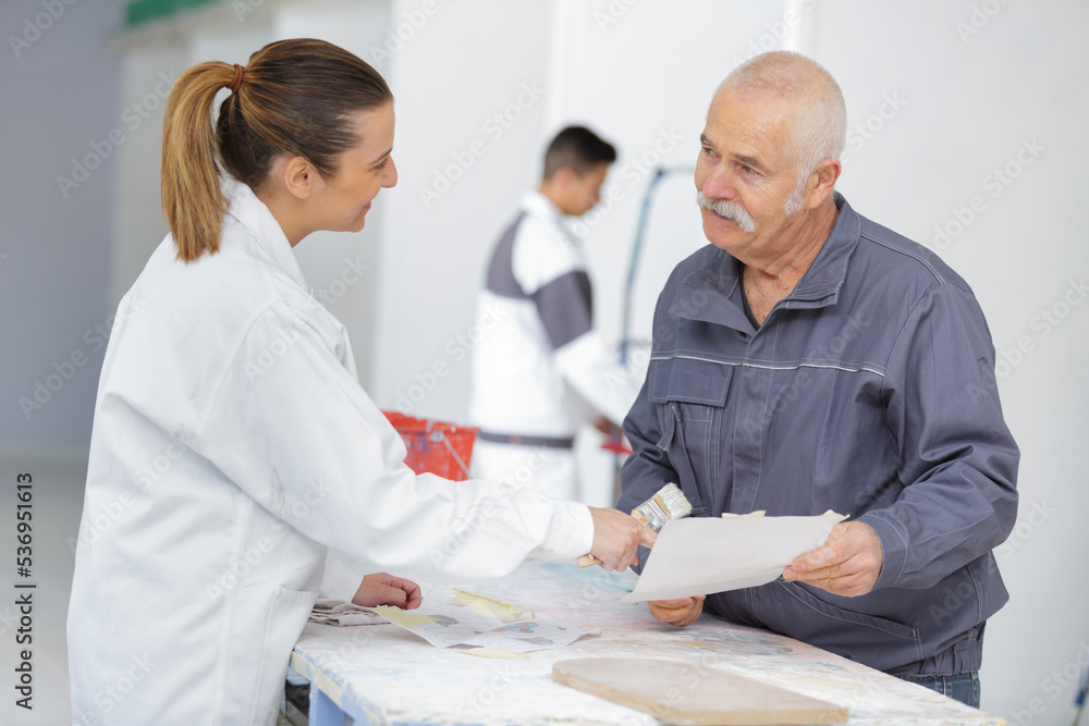 woman signing document with male painter at home woman signing document with male painter at home