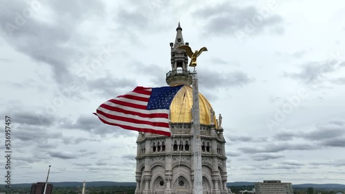 American flag waves by Hartford Connecticut state capitol dome. Aerial in Bushnell Park. photo