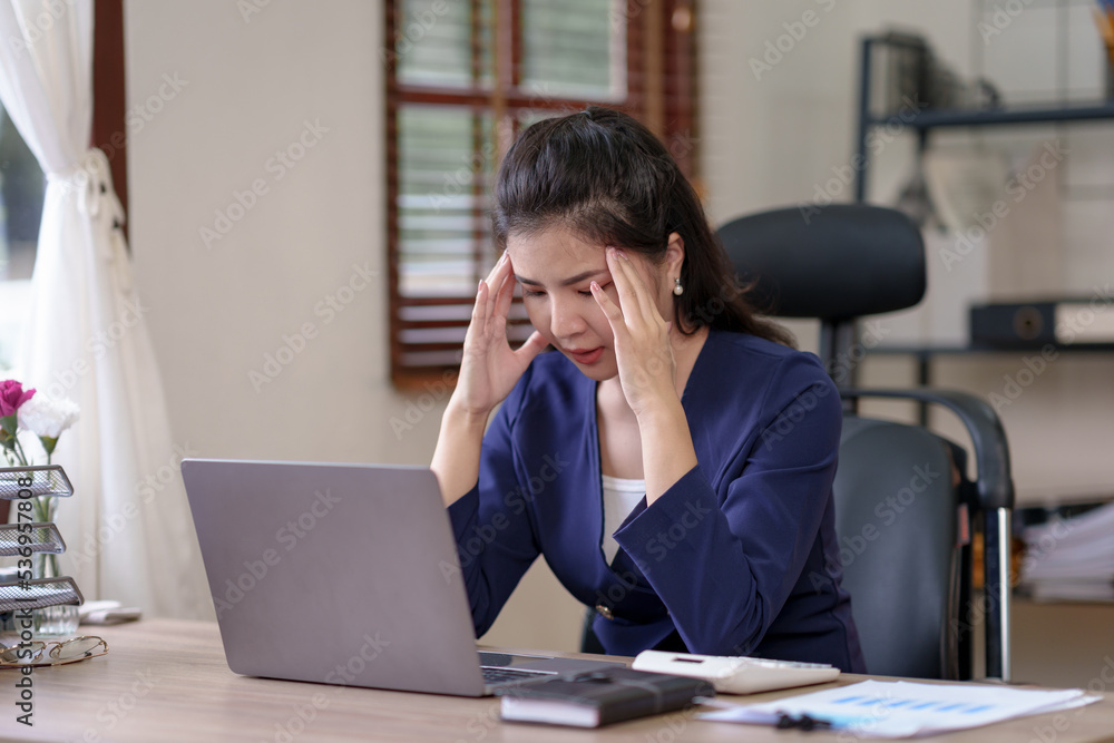 Asian businesswoman sitting in the office feeling tired, stressed or exhausted from a long day at work. Asian businesswoman sitting in the office feeling tired, stressed or exhausted from a long day at work.