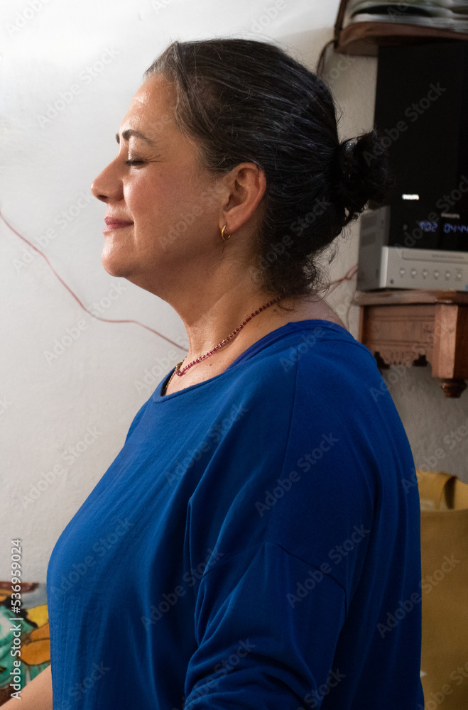 Fototapeta premium middle-aged yoga teacher is relaxed on her mat as she supervises her students in a private class.