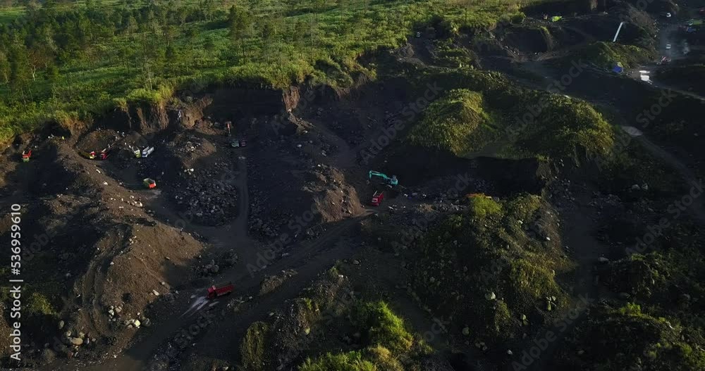 Industrial Machinery digging in wilderness on slope of volcano for sand mining Industrial Machinery digging in wilderness on slope of volcano for sand mining