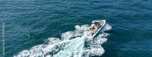 Aerial drone top down ultra wide photo with copy space of inflatable speed boat with wooden deck cruising in high speed in deep blue Aegean sea