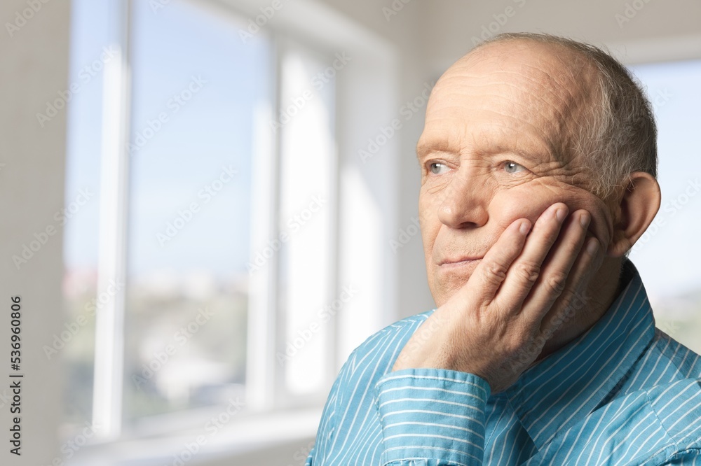 Serious old man looks in the window with nostalgia Serious old man looks in the window with nostalgia